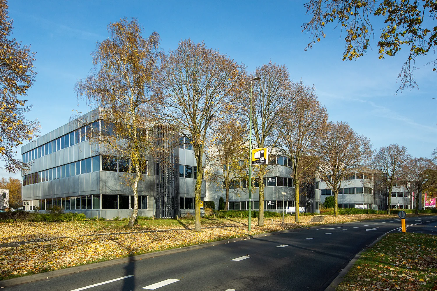 Kantoorgebouwen aan de Huis-ter-Heideweg te Zeist, omringd door bomen met herfstbladeren.
